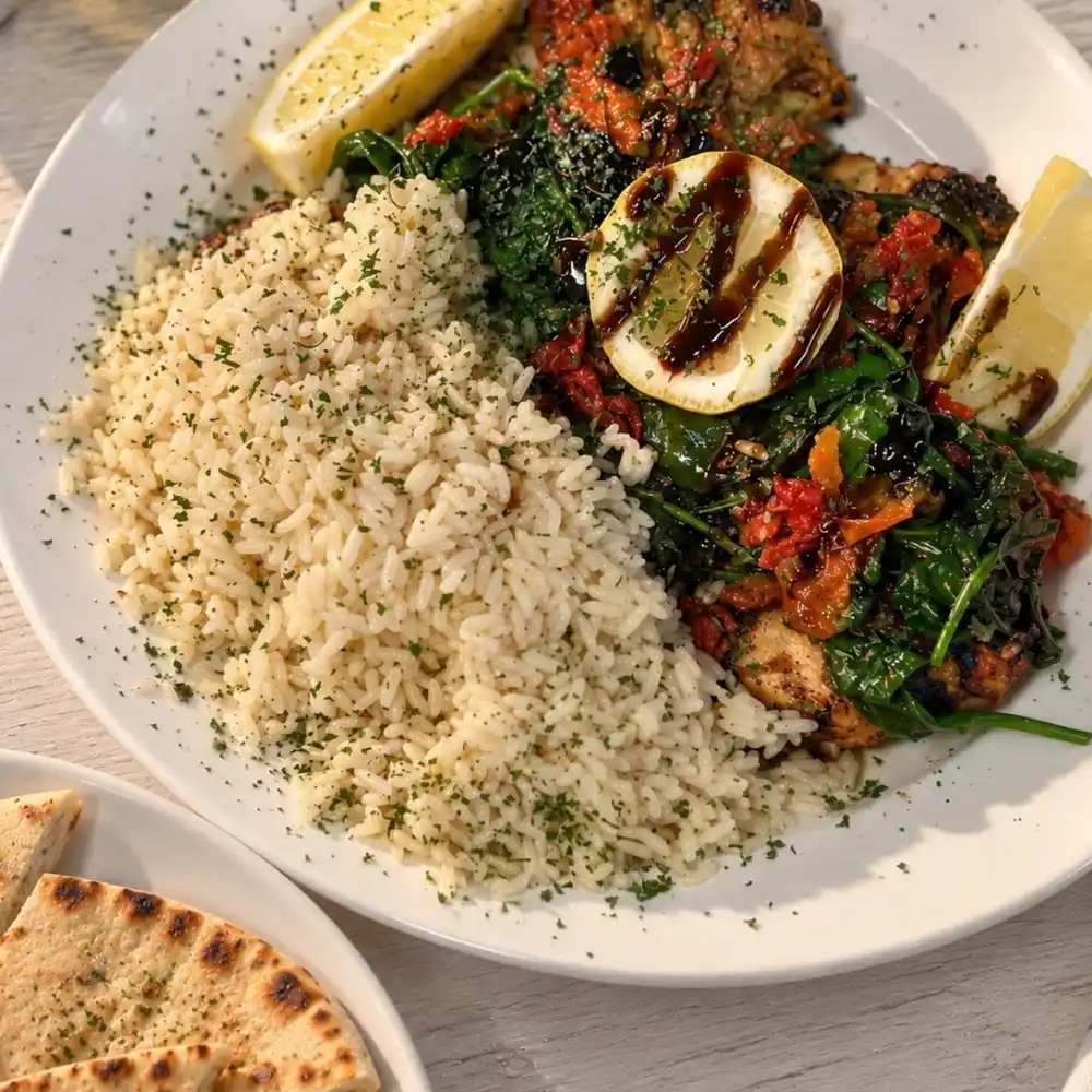 Chicken florentine topped with spinach, sun-dried tomatoes, feta and a fig balsamic drizzle, next to Greek rice