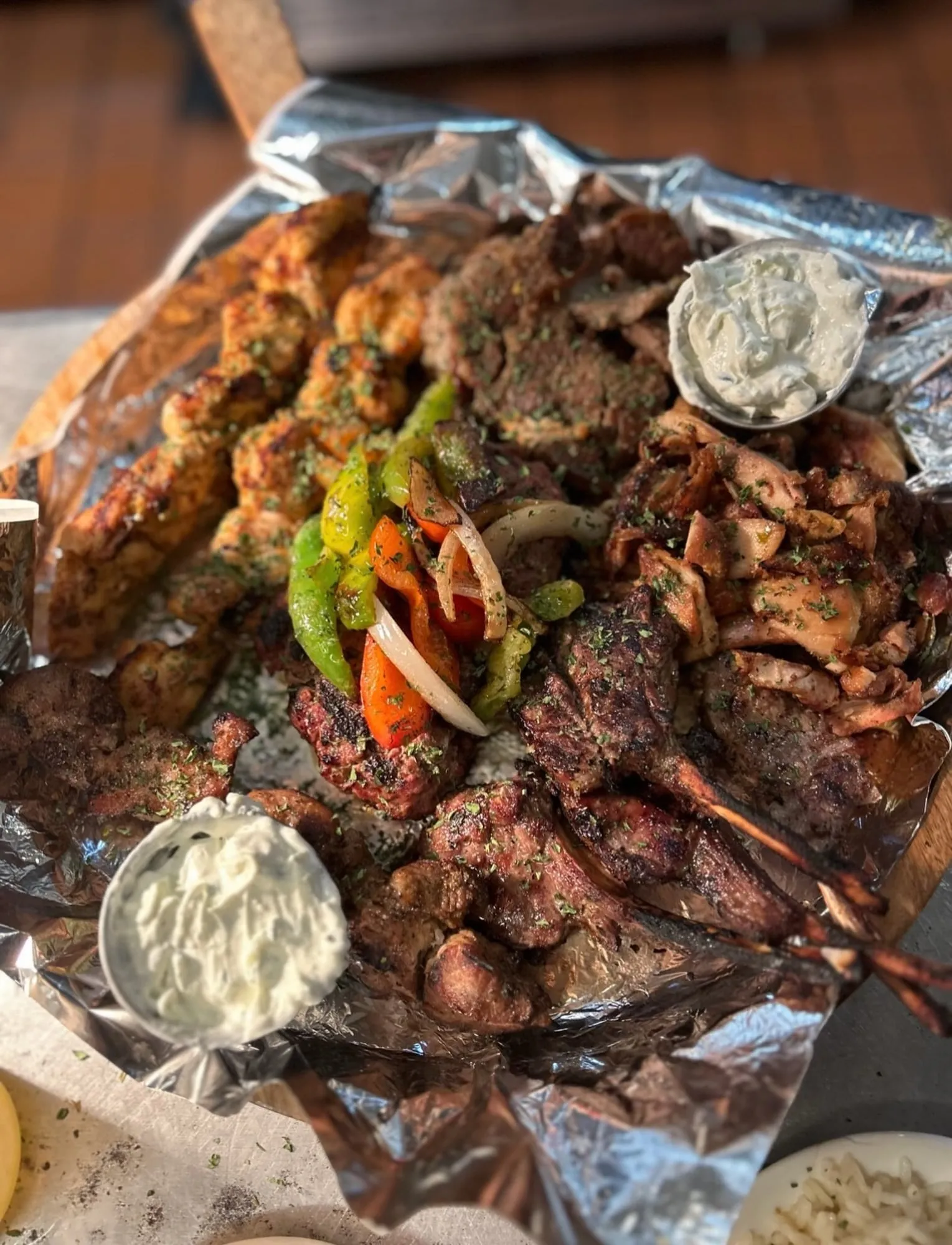The Piato mixed grill: lamb chops, souvlaki, gyro and beefteki on foil with peppers and tzatziki