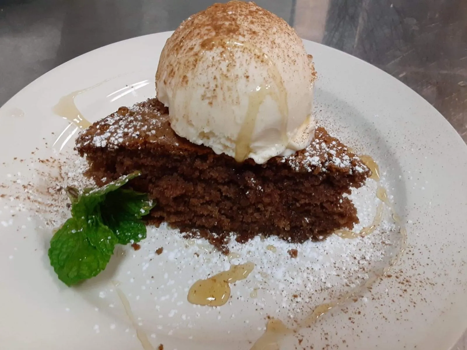 A slice of sokolatopita, Greek chocolate pie, with a scoop of vanilla ice cream and honey